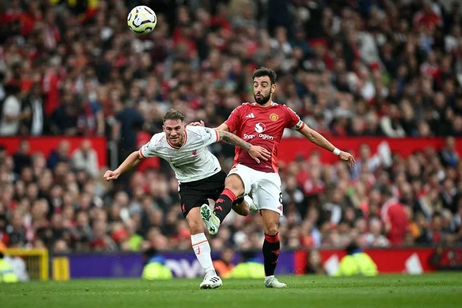 Alexis Mac Allister, del Liverpool, disputa el balón con Bruno Fernandes, del Manchester United